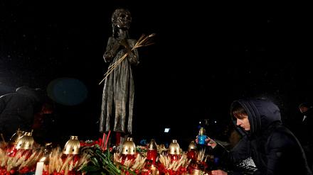 A woman places a candle at a monument to Holodomor victims during a commemoration ceremony of the famine of 1932-33, in which millions died of hunger, amid Russia's attack on Ukraine, in Kyiv, Ukraine November 26, 2022. REUTERS/Valentyn Ogirenko REFILE - CORRECTING YEAR