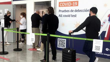 Reisende warten vor einem Testzentrum am Flughafen von Palma des Mallorca.