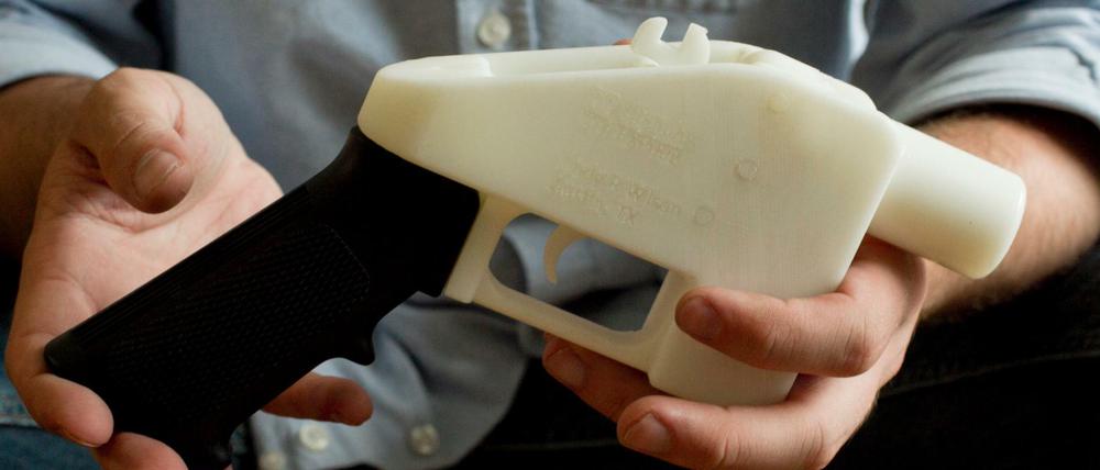 Eine Person hält eine Plastik-Pistole, die komplett im 3D-Drucker hergestellt wurde.