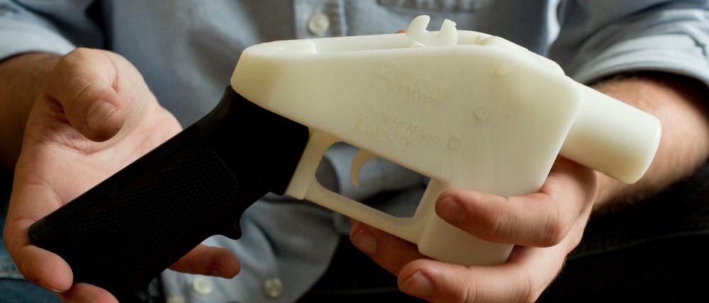  Eine Person hält eine Plastik-Pistole, die komplett im 3D-Drucker hergestellt wurde.