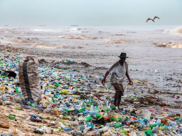 Ein Mann sammelt bei Accra in Ghana verwertbares Material am verschmutzten Korle Gono Strand.
