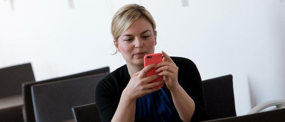 Die Landtagsabgeordnete Katharina Schulze (Bündnis 90/Die Grünen) schaut in ihr Handy. 
