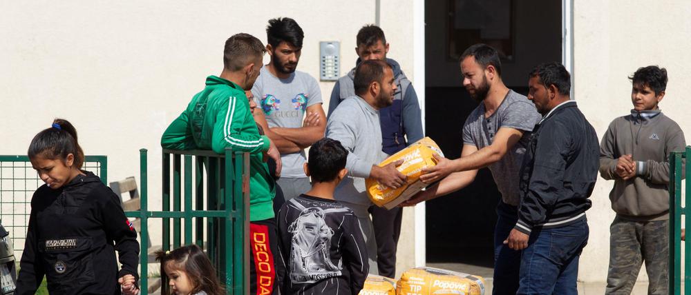 Roma in Podgorica in Montenegro teilen eine Lebensmittellieferung des Roten Kreuzes mit ihren Nachbarn.