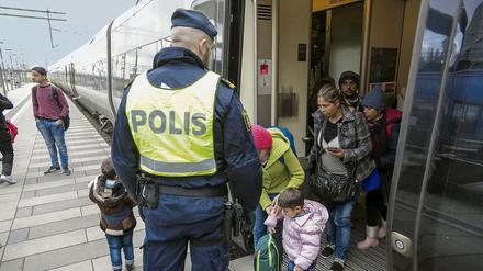 Ein schwedischer Polizist empfängt auf dem Bahnhof in Malmö Flüchtlinge. 