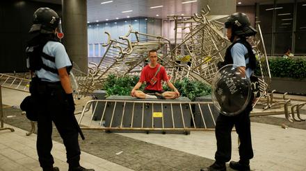 Nach den gewaltsamen Auseinandersetzungen am Ende der Demonstration in Hongkong stehen zwei Polizisten vor einem Demonstranten.