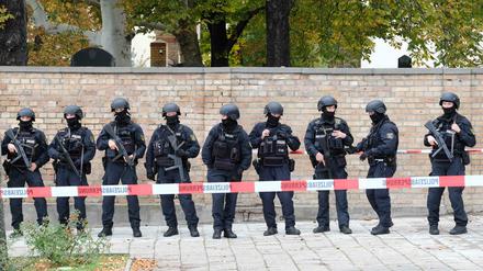 Polizisten vor der Mauer des jüdischen Friedhofs in Halle. 