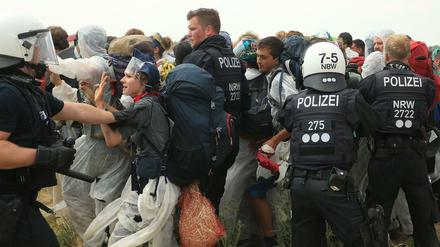 Polizisten versuchen, die Klimaschützer daran zu hindern, in den Tagebau Garzweiler einzudringen.