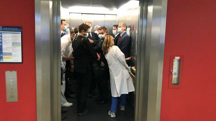 In der Uniklinik Gießen drängen sich Gesundheitsminister Jens Spahn (CDU, l), und Hessens Ministerpräsident Volker Bouffier (CDU, M) mit Begleitern in einem Fahrstuhl.