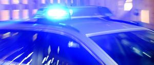 Ein Streifenwagen der Polizei steht mit eingeschaltetem Blaulicht auf der Straße