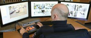 Ein Polizist überwacht in Duisburg an Monitoren die übertragenen Bilder von Videokameras.