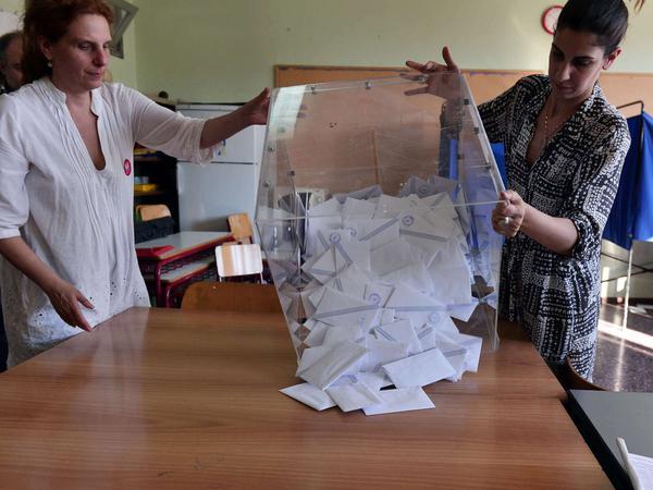 Wahlhelfer beim Referendum in Griechenland leeren die Wahlurne. 