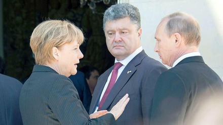 Der Präsident der Ukraine, Petro Poroschenko (Mitte), im Gespräch mit Angela Merkel und Russlands Präsident Wladimir Putin am vergangenen Freitag in Frankreich.. 
