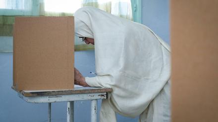Eine Tunesierin füllt ihren Stimmzettel in der Wahlkabine aus. Rund sieben Millionen Tunesier sind an diesem Sonntag aufgerufen, einen neuen Präsidenten zu wählen.
