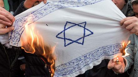 Jugendliche verbrennen in Neukölln nach einer Pro-Palästina-Demonstration eine selbst gebastelte Israel-Fahne.