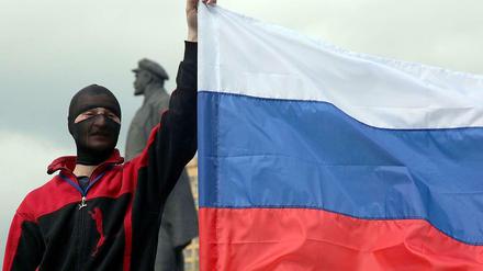Ein prorussischer Aktivist hält eine russische Flagge hoch. 