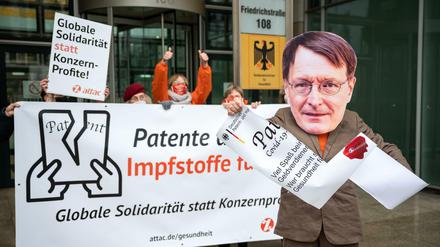 Aktivisten der globalisierungskritischen Organisation Attac demonstrieren vor dem Bundesministerium. Ein Demonstrant trägt eine Maske mit einem Foto von Bundesgesundheitsminister Lauterbach. Attac fordert die Aussetzung der Patente für Covid-Impfstoffe. 