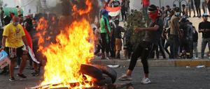 Demonstranten verbrennen in Bagdad Reifen.