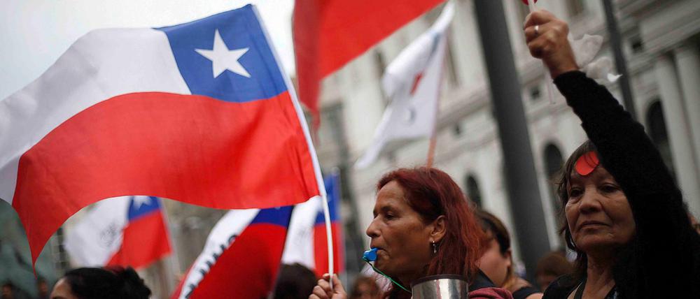 Frauen wehen Flaggen von Chile bei einem Protest für Sozialreformen. 