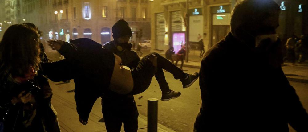 Ein Demonstrant trägt eine verletzte Frau.