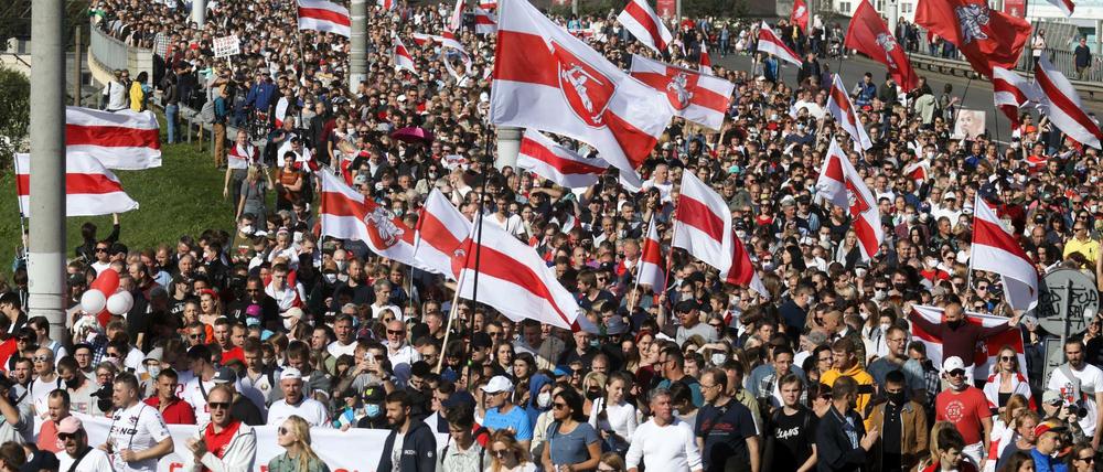 Aufmarsch in Minsk. Demonstranten halten historische belarussische Flaggen und nehmen an einem Protest der Opposition teil (13.9.2020).
