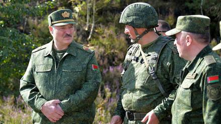 Alexander Lukaschenko (l), Präsident von Belarus, spricht bei einer Militärübung mit hochrangigen Offizieren. 