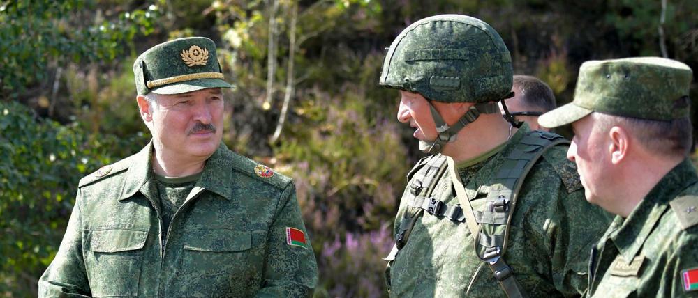 Alexander Lukaschenko (l), Präsident von Belarus, spricht bei einer Militärübung mit hochrangigen Offizieren. 