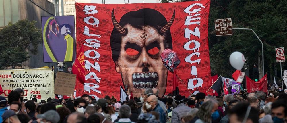 Demonstranten in Sao Paulo tragen ein Transparent mit dem Konterfei des brasilianischen Präsidenten Bolsonaro in der Gestalt eines Teufels.