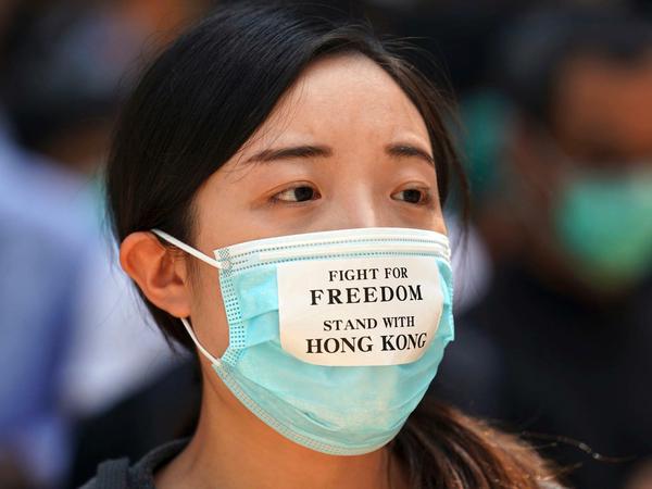 Eine prodemokratische Demonstrantin trägt eine Maske.