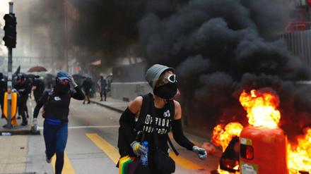 Ausschreitungen in Hongkong: Demonstranten laufen an brennenden Barrikaden vorbei. 