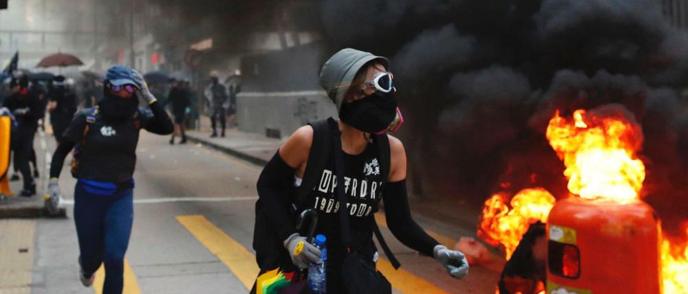 Ausschreitungen in Hongkong: Demonstranten laufen an brennenden Barrikaden vorbei. 