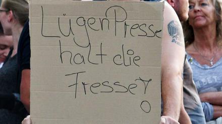 Ein Teilnehmer einer Kundgebung rechter Gruppen in Köln hält ein Plakat mit der Aufschrift "Lügenpresse halt die Fresse". 