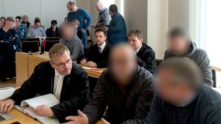 Die vier angeklagten Männer (erste Reihe 2. und 3. v.l. und zweite Reihe 1. und 4. v.l.) am Montag im Amtsgericht in Kamenz (Sachsen) neben ihren Anwälten.