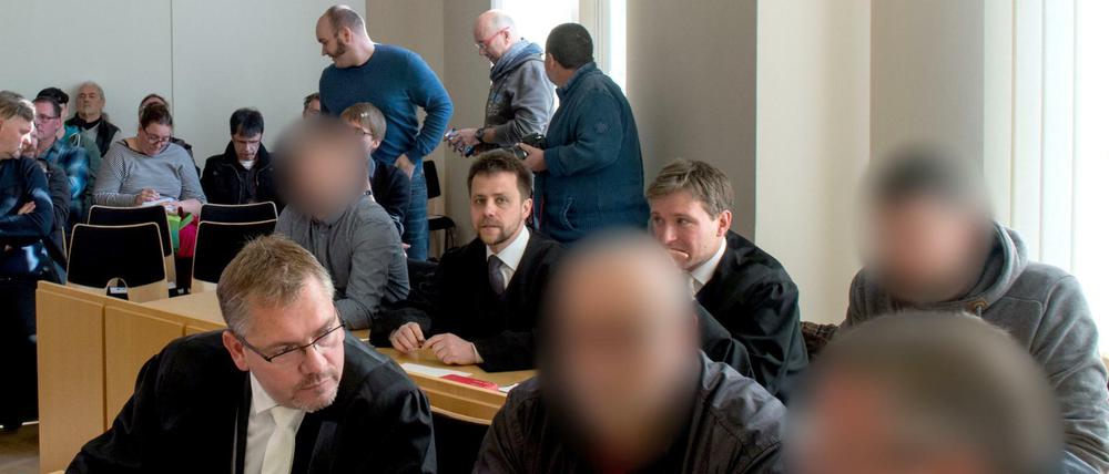 Die vier angeklagten Männer (erste Reihe 2. und 3. v.l. und zweite Reihe 1. und 4. v.l.) am Montag im Amtsgericht in Kamenz (Sachsen) neben ihren Anwälten.
