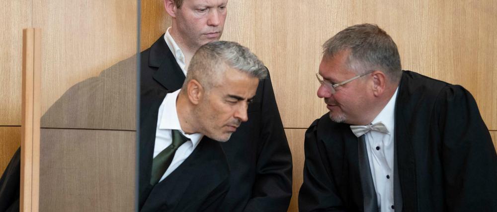 Der Hauptangeklagte im Mordfall Lübcke, Stephan Ernst (M), spricht im Oberlandesgericht mit seinen Anwälten Mustafa Kaplan (l) und Frank Hannig. 