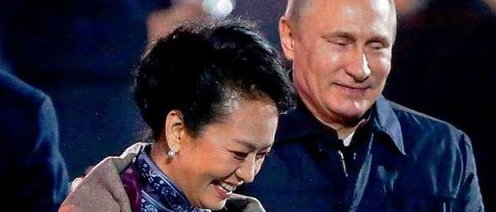 Kleine Geste, große Wirkung. Wladimir Putin legt Chinas First Lady in eisiger Kälte eine Decke um die Schulter.
