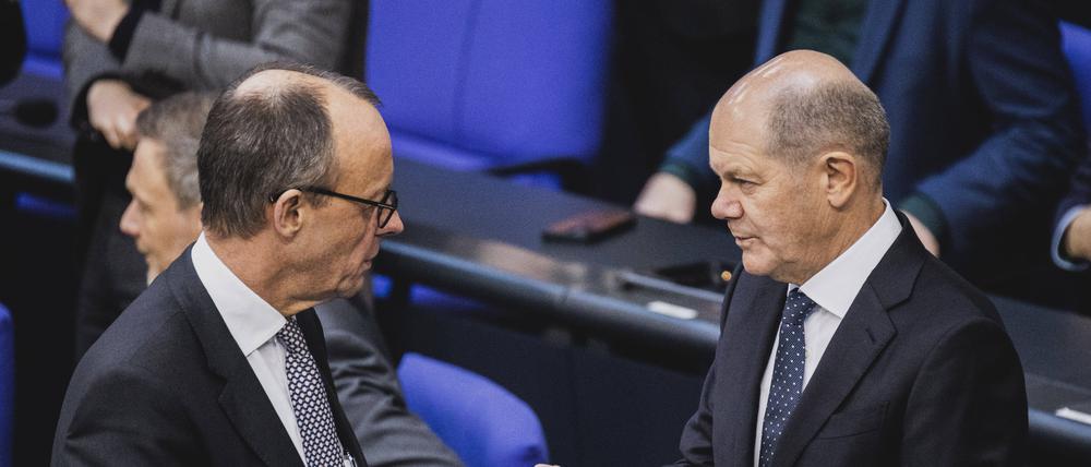 Bundeskanzler Olaf Scholz (SPD) und Unionsfraktionschef Friedrich Merz (CDU) sprechen am Rand einer Sitzung des Deutschen Bundestages (Symbolbild).
