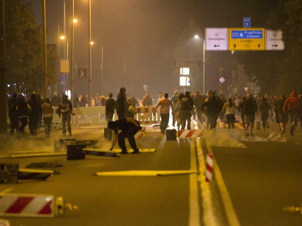 Rechtsextremisten rennen in Heidenau eine Straße entlang.