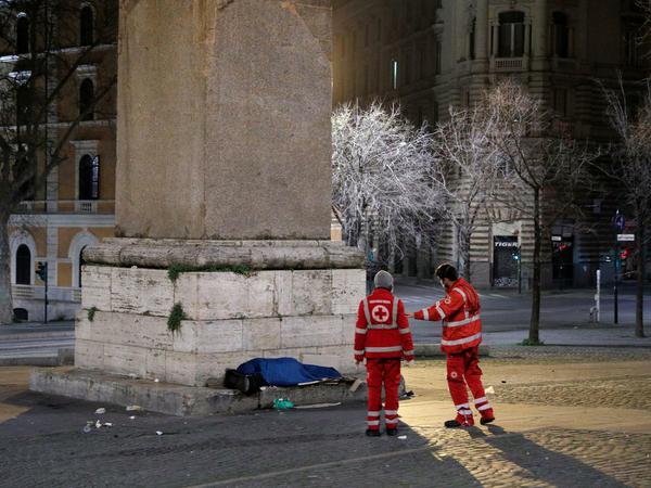 Helfer des Roten Kreuzes kümmern sich um einen Obdachlosen in Rom.