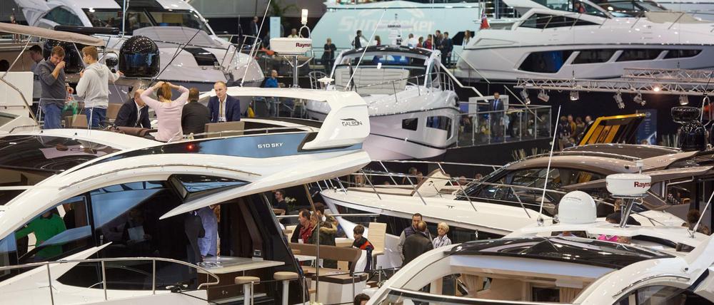 Besucher stehen bei der Messe Boot auf den Decks von Luxusjachten