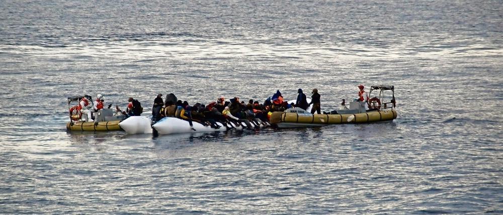 Rettung aus Seenot. Italienische Marinesoldaten helfen Flüchtlingen vor der Küste Siziliens.