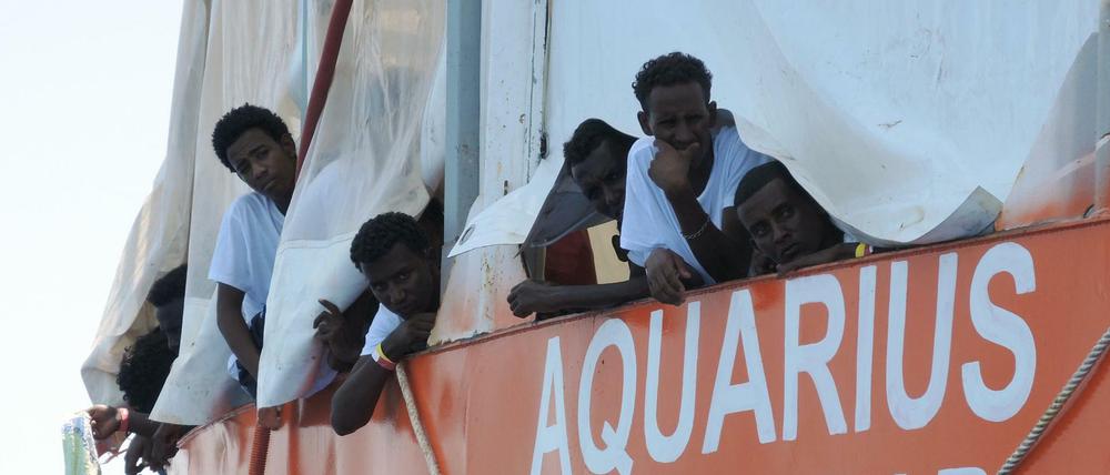 Aus Seenot gerettete Migranten blicken von dem Rettungsschiff "Aquarius" herunter.