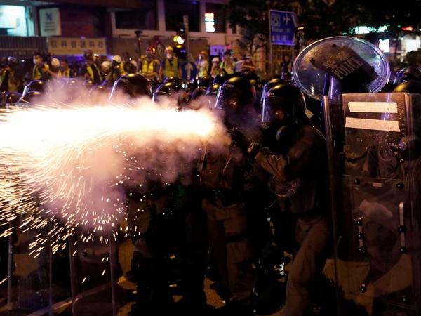 Die Polizei feuert Tränengas auf die Demonstranten.