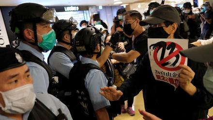 Polizisten und Demonstranten diskutieren in einem Einkaufszentrum in Hongkong.