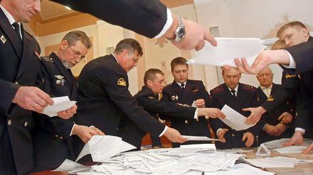 Mitglieder der Wahlkommission zählen Stimmzettel aus. 