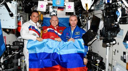 Die russischen Kosmonauten Oleg Artemyev, Denis Matveev and Sergey Korsakov posieren mit Flaggen der sebsternannten "Volksrepublik" Luhansk