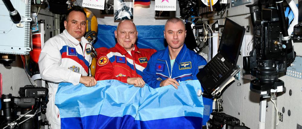 Die russischen Kosmonauten Oleg Artemyev, Denis Matveev and Sergey Korsakov posieren mit Flaggen der sebsternannten "Volksrepublik" Luhansk