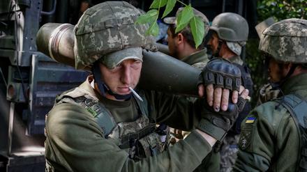 Ein ukrainischer Soldat mit Raketen für eine amerikanische M777 Haubitze im Donbass.