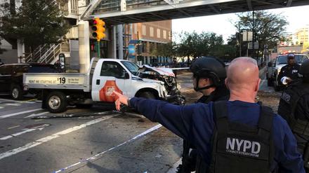 Polizisten stehen in der West Street in New York (USA) vor dem Tatfahrzeug.