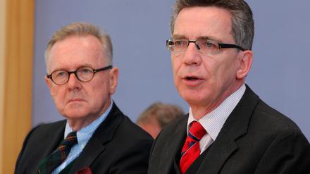 Der Präsident des Bundesamtes für Migration und Flüchtlinge, Albert Schmid (l) und Bundesinnenminister Thomas de Maiziere (CDU) vor der Bundespressekonferenz in Berlin.