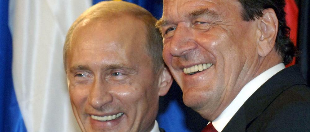 Lachend steht der damalige Bundeskanzler Gerhard Schröder (r) 2005 in Berlin neben dem russischen Präsidenten Wladimir Putin.